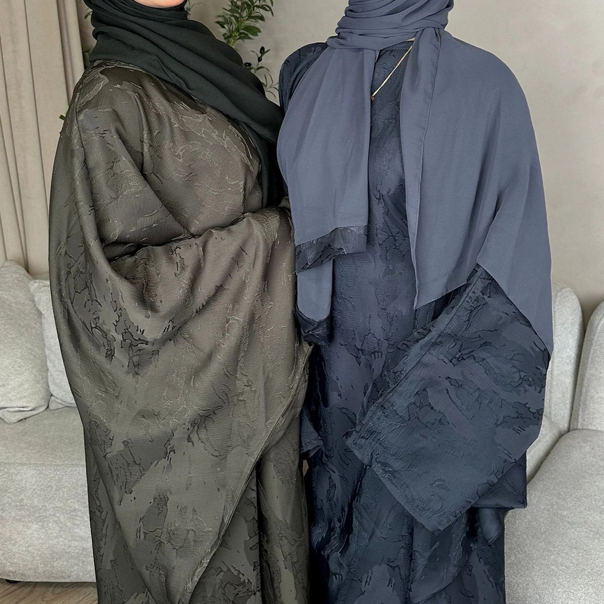 Model in a printed abaya with matching hijab in olive and navy