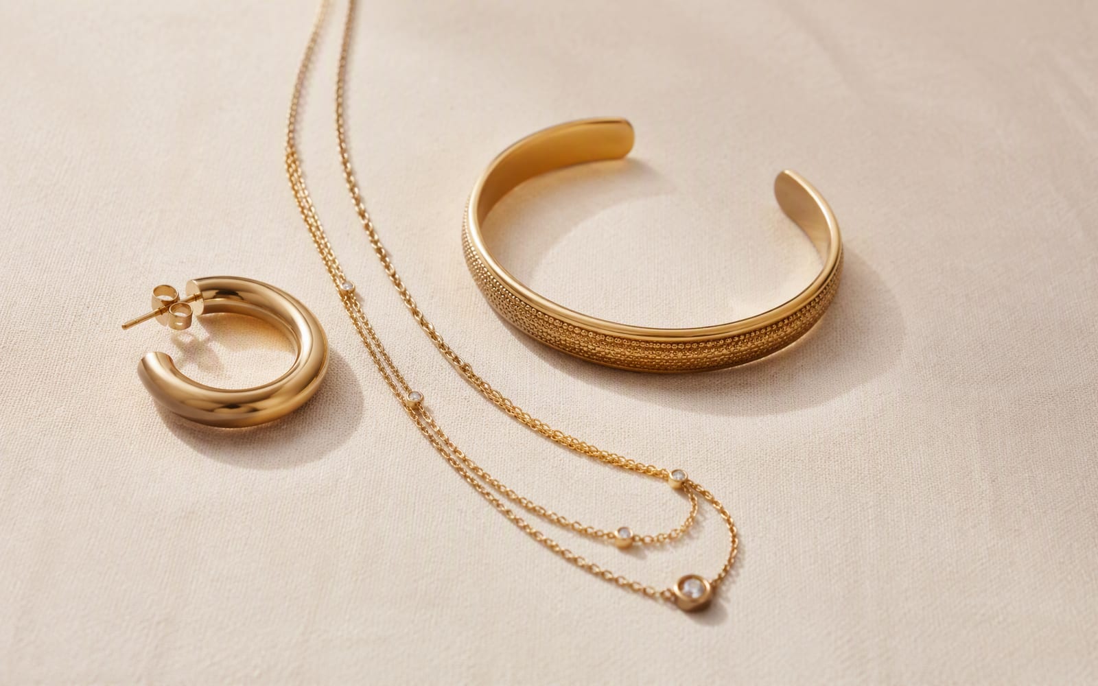 Gold-plated brass hoops, cuff bracelet and layered chain necklace